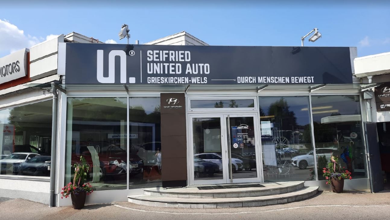 Eingangsbereich des Autohauses Seifried United Auto in Grieskirchen mit Hyundai-Logo und Glasfassade.